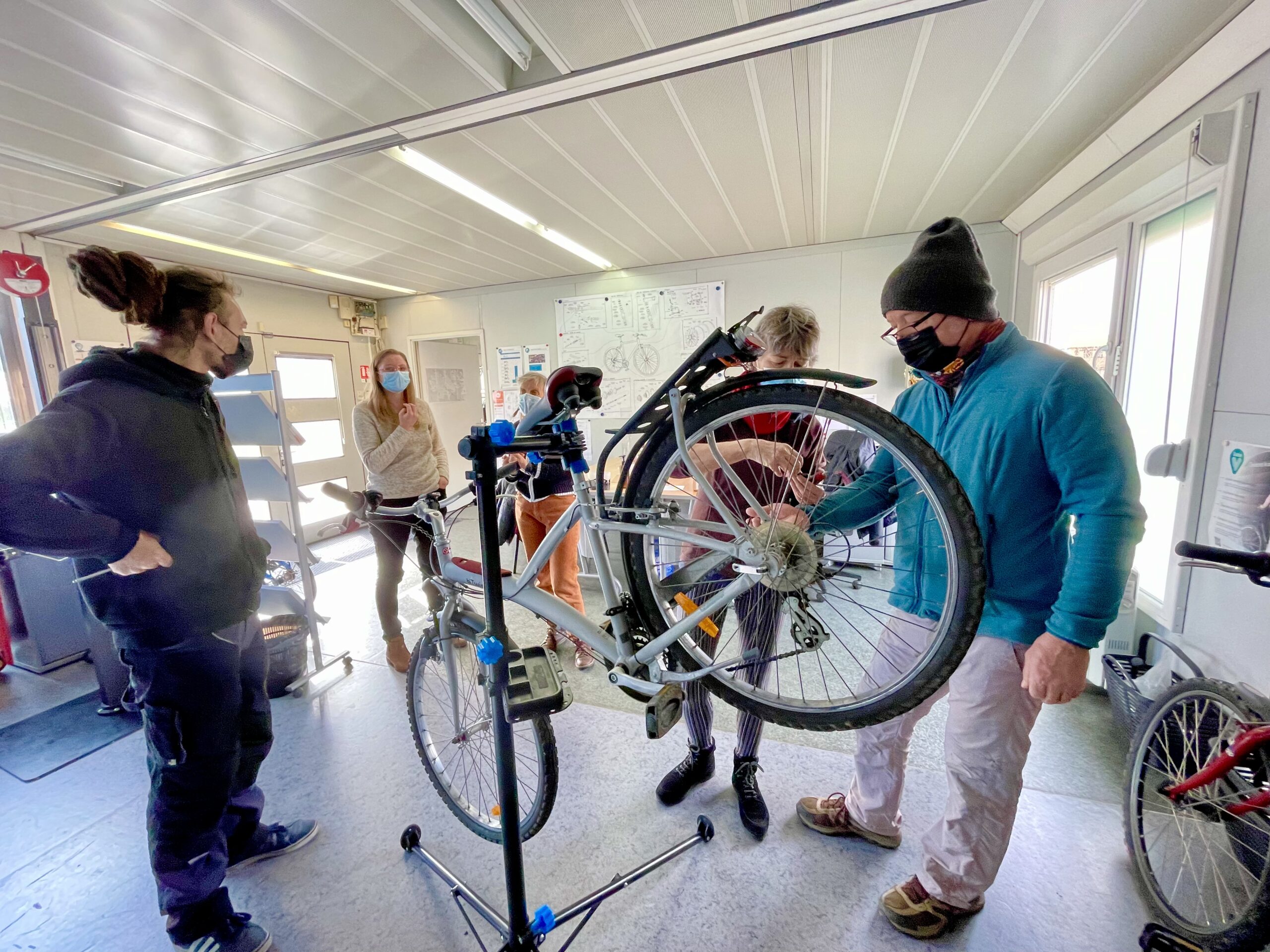 personnes autour d'un vélo en réparation