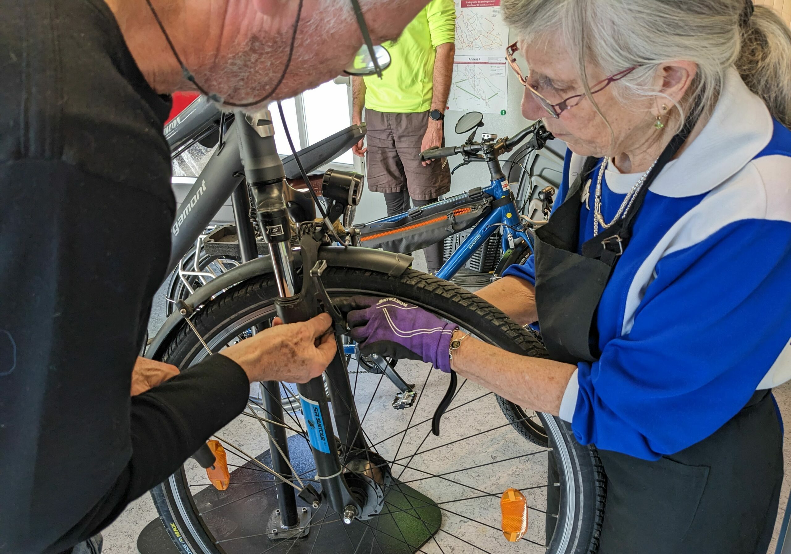 homme réparant le dérailleur d'un vélo bleu